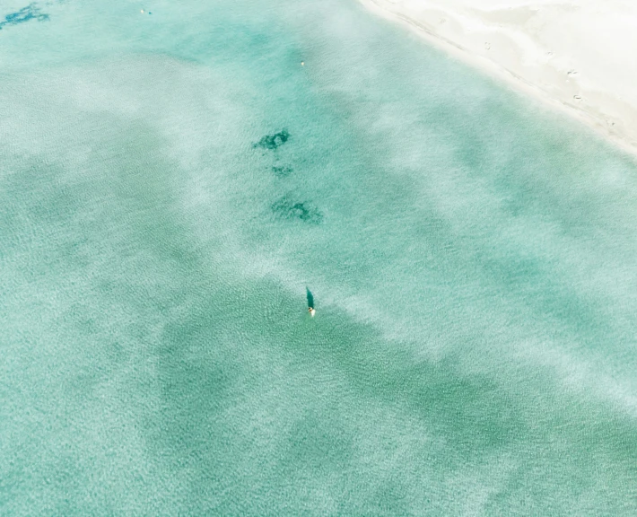 the beach is covered in water and has footprints in the sand