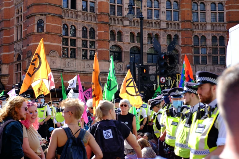 a group of people walking with police holding flags