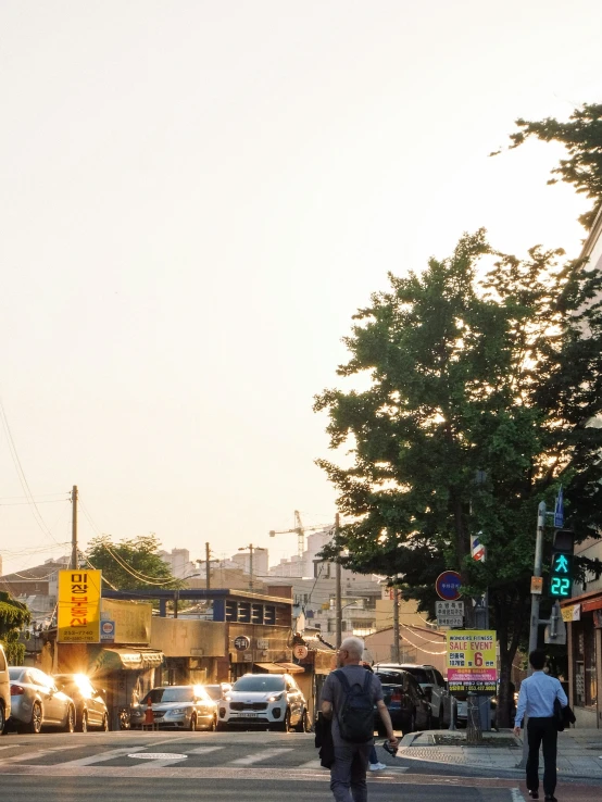 a few people and cars on a city street