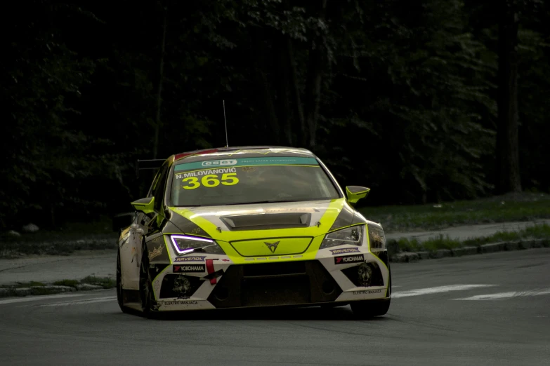 a yellow car racing down a hill on a race track