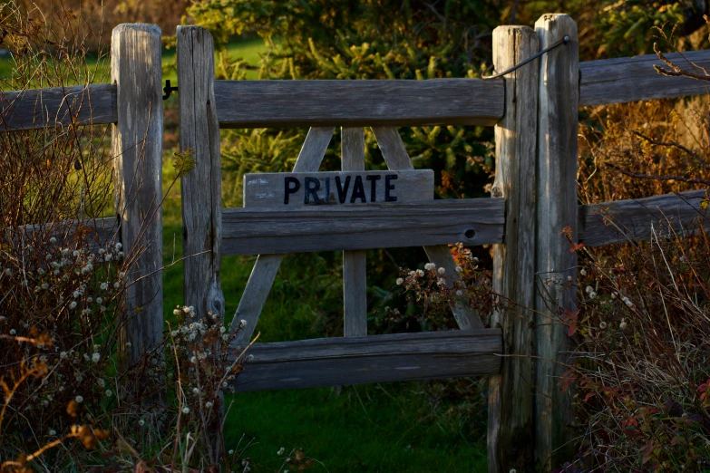 a wooden gate with a private sign mounted on the side