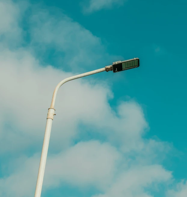 a traffic light is in front of a cloudy blue sky