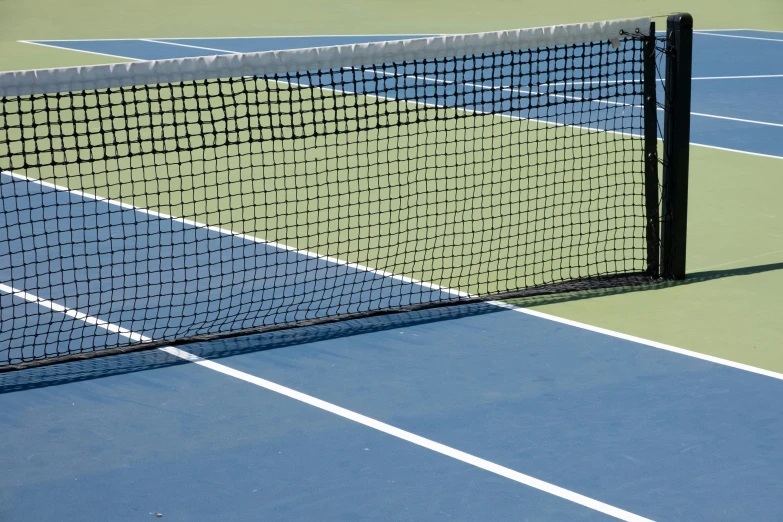 tennis court with a ball and racket in the foreground