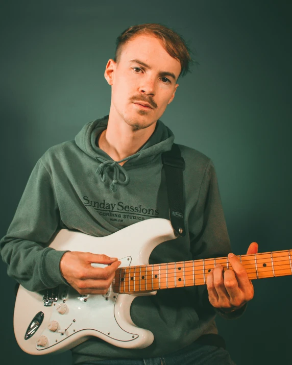 a man is holding a white guitar