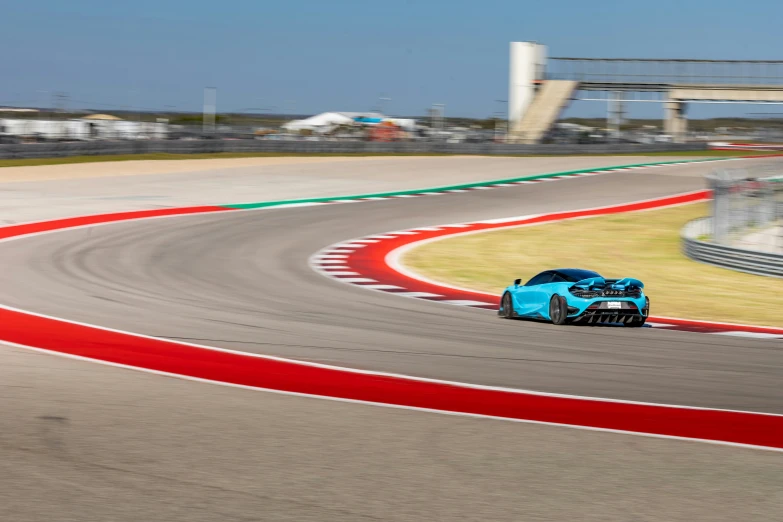 a blue racing car racing around a track