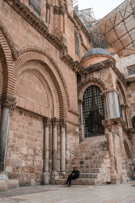 two men sitting on some steps near an old building