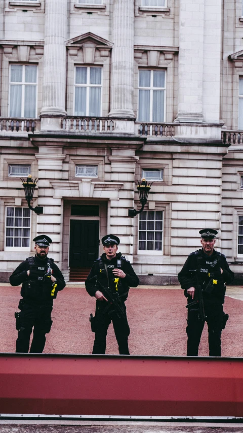 three police officers are standing outside the building