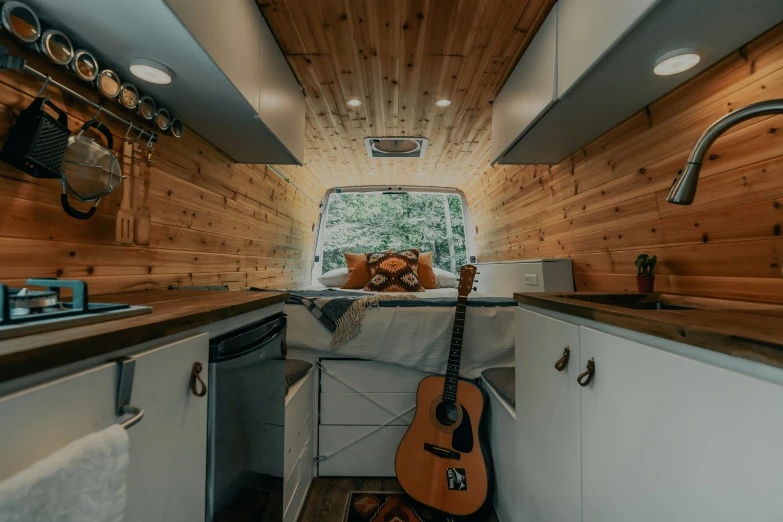 the interior of a tiny rv with sink, stove and oven