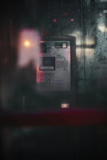 an old fashioned phone is next to a rainy window