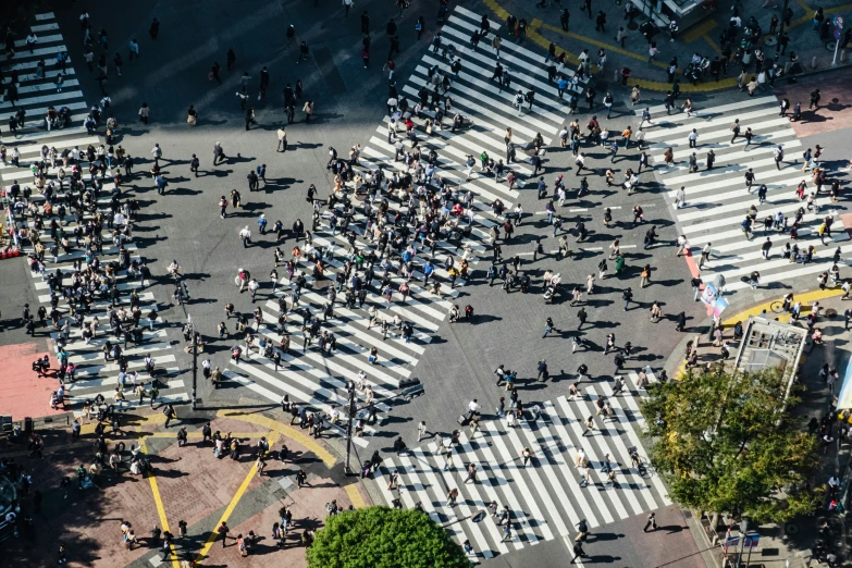 an aerial po of many people crossing the street