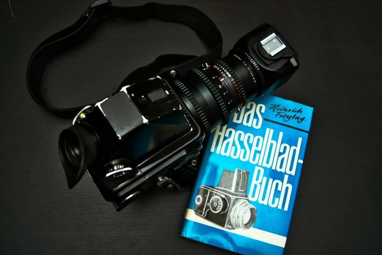 camera and lens on top of book with flash camera
