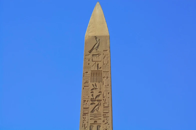 a large tall obelisk with egyptian writing and numbers