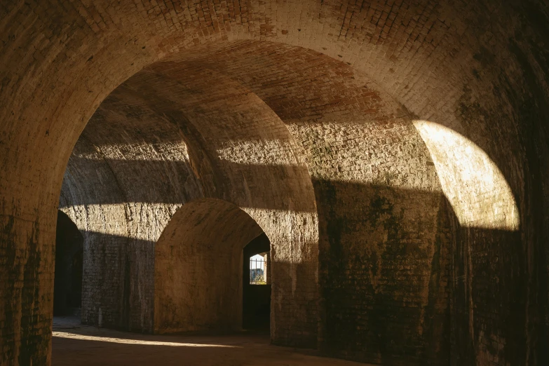 a very old brick tunnel with sunshine coming in