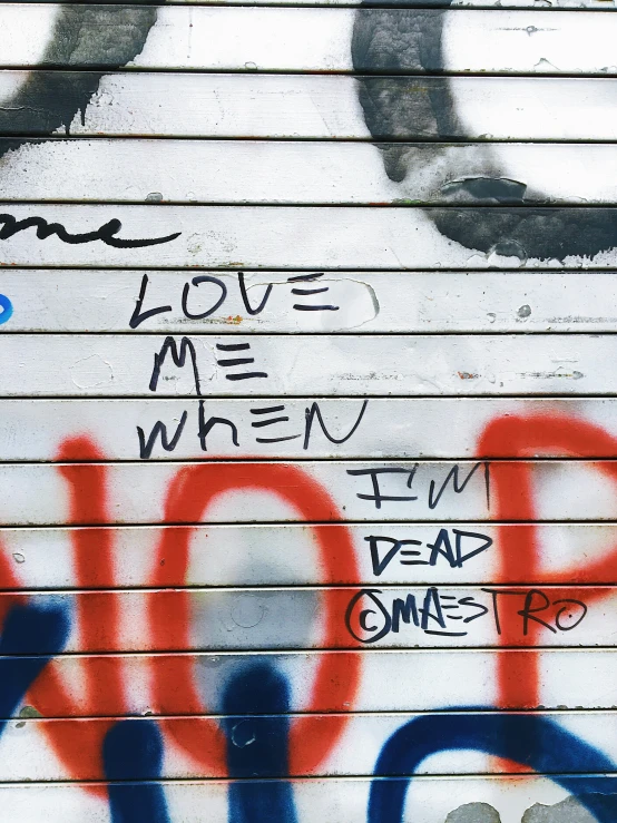 the word love me when i'm dead came up painted on a wall