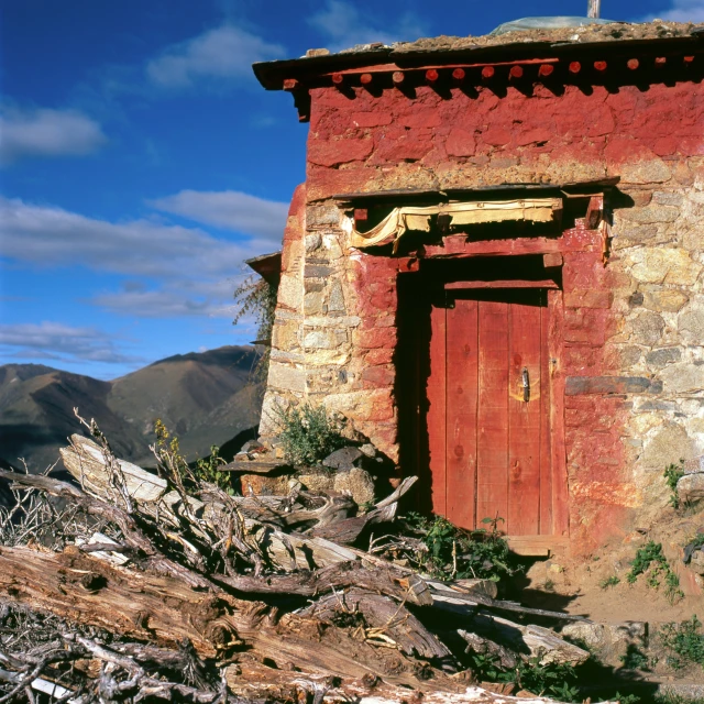 a small brick structure with a red door