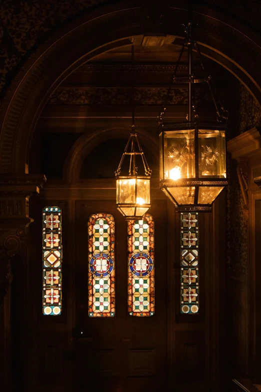 three stained glass windows hanging on a ceiling