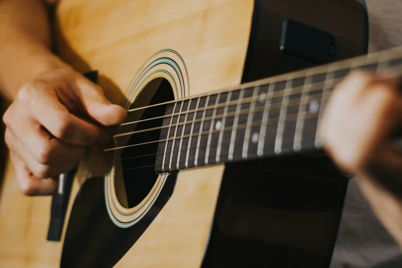 someone playing a guitar with their hands and fingers