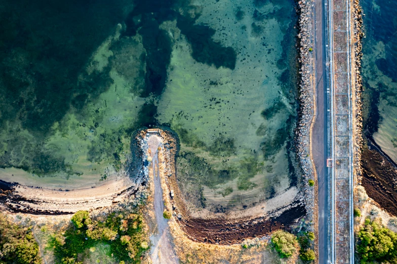 an overhead view of the road and beach by the water