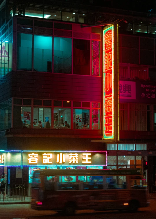 an asian sign lit up at night in front of a building
