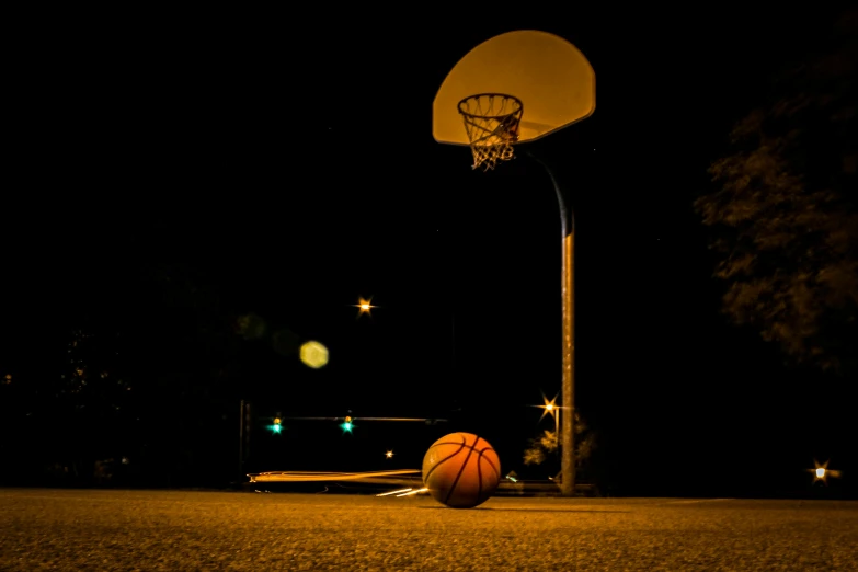 a basketball is laying on the ground in front of a basketball hoop