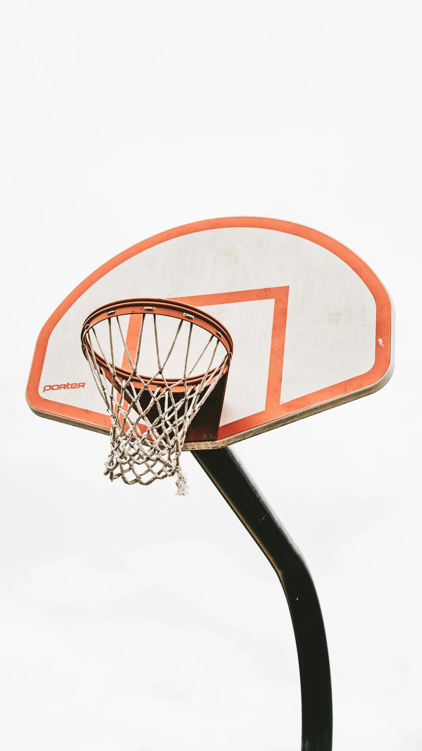 an empty basketball hoop is pictured against a cloudy sky