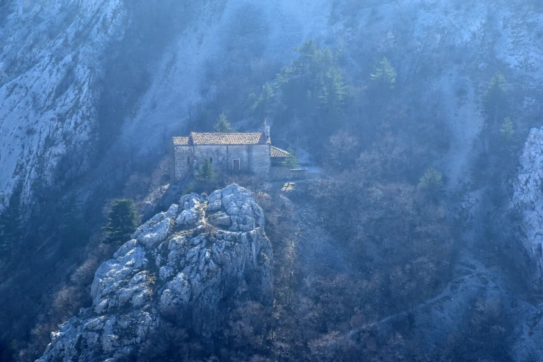 the top of a mountain with a building in the middle