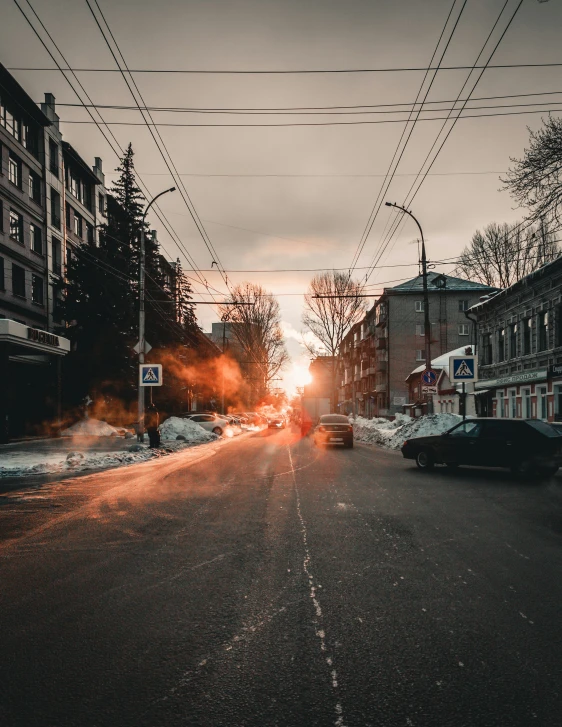 the street in front of some buildings at sunset