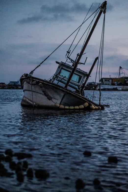 a boat is sinking in the water while another yacht sits on it