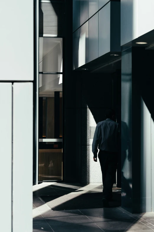 a person walking on a sidewalk in front of a building