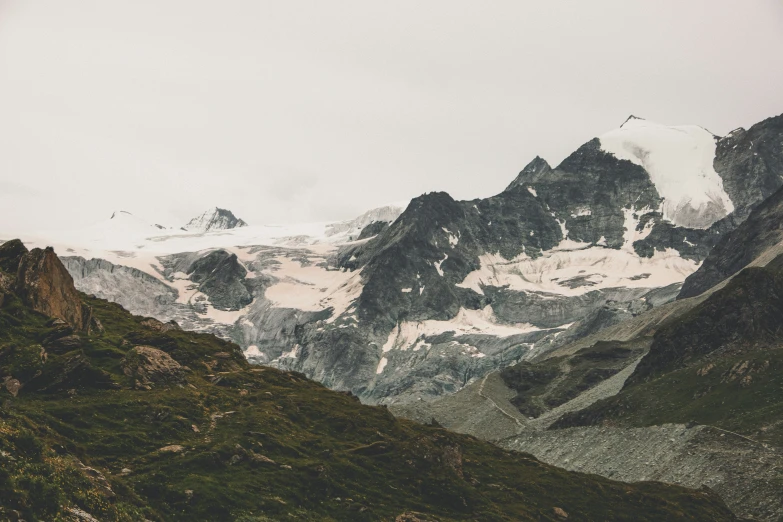 snow covered mountains are seen on the side of the road