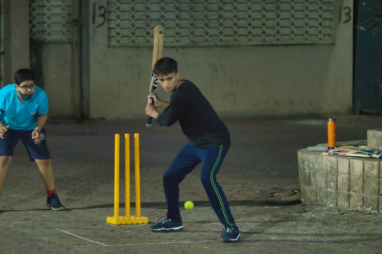 two men playing with a ball and bat