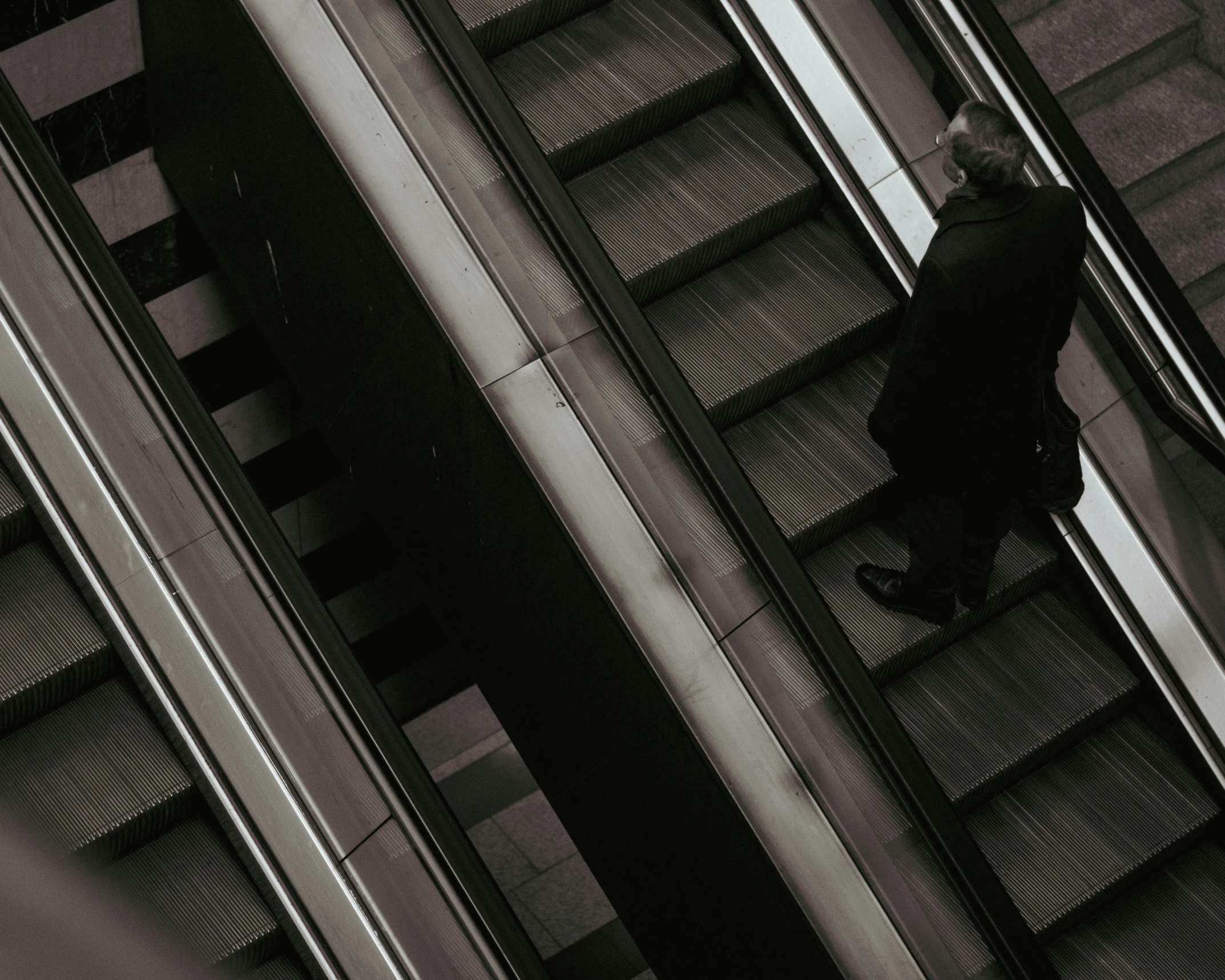 a man in black walking down some stairs