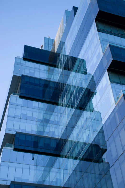 large building with multiple windows reflected in another building's facade