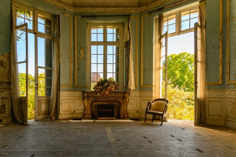 a room with multiple large windows and chairs near a fireplace