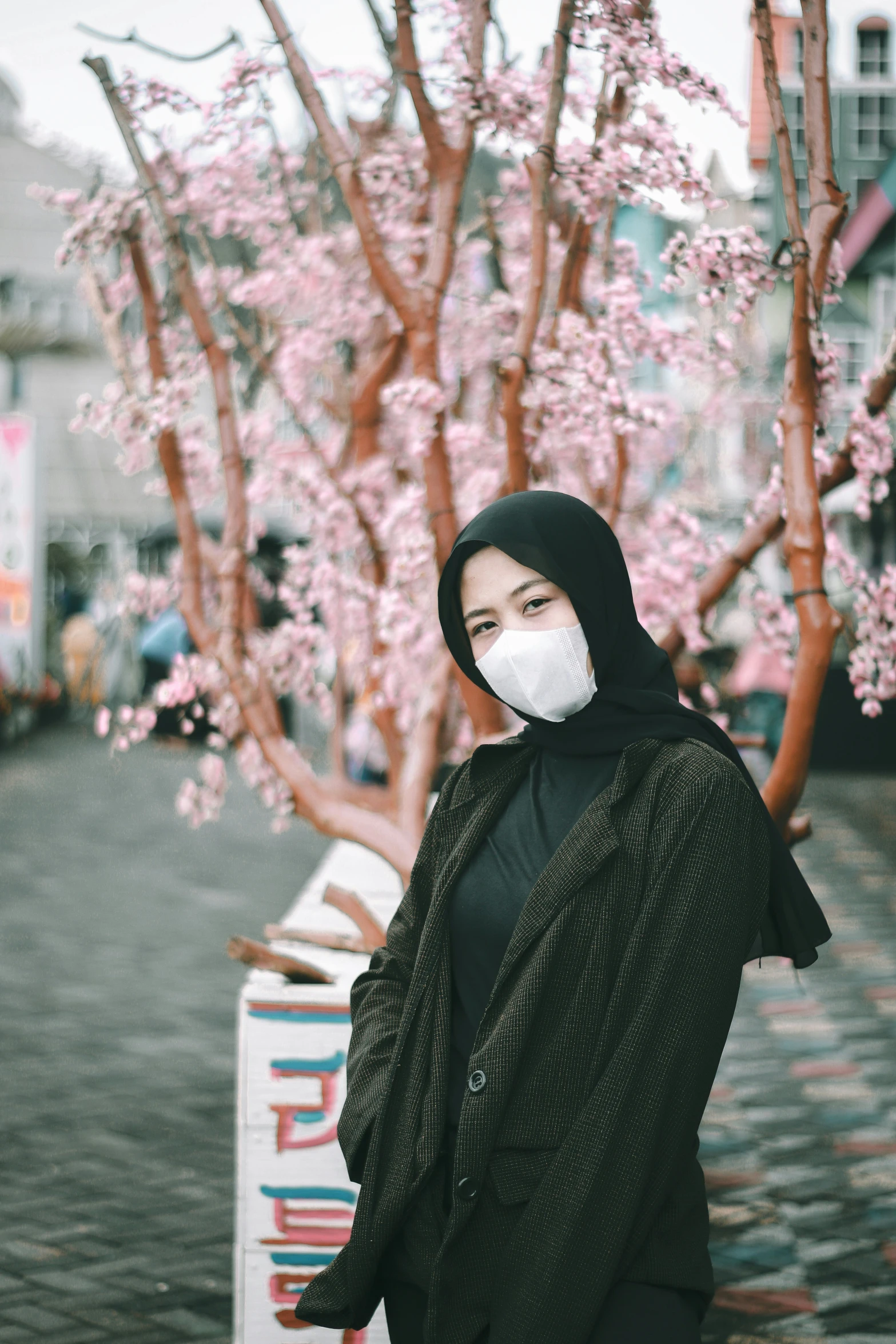 woman wearing face mask standing on cobblestone road