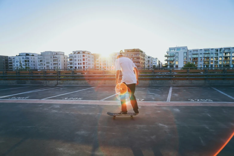 a man riding a skateboard through an empty parking lot