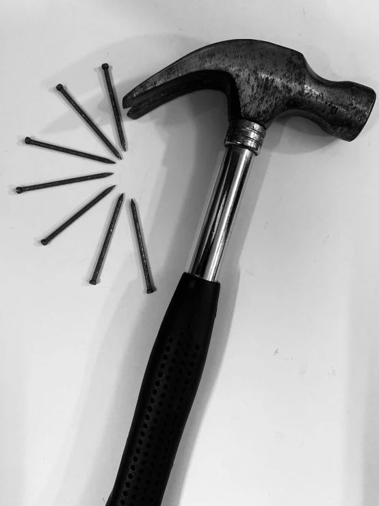 a hammer and nails sit on a white surface