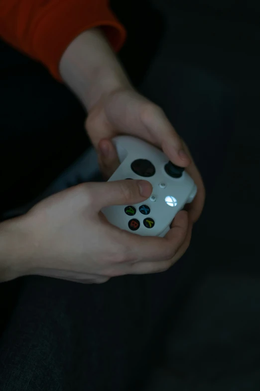 a person holding a white remote control for a video game