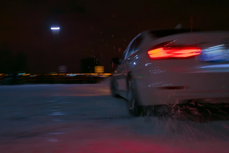 a white car driving down the road at night