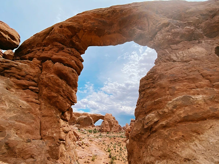 an arch shaped natural rock formation in the desert