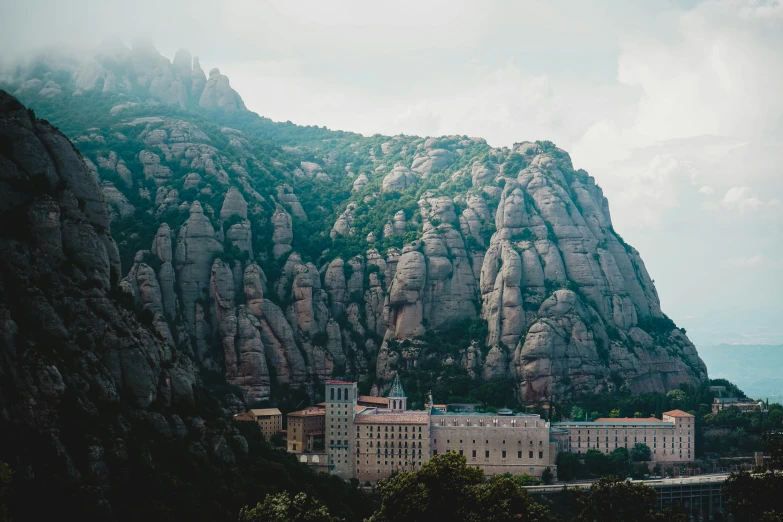 an old stone building next to a big cliff