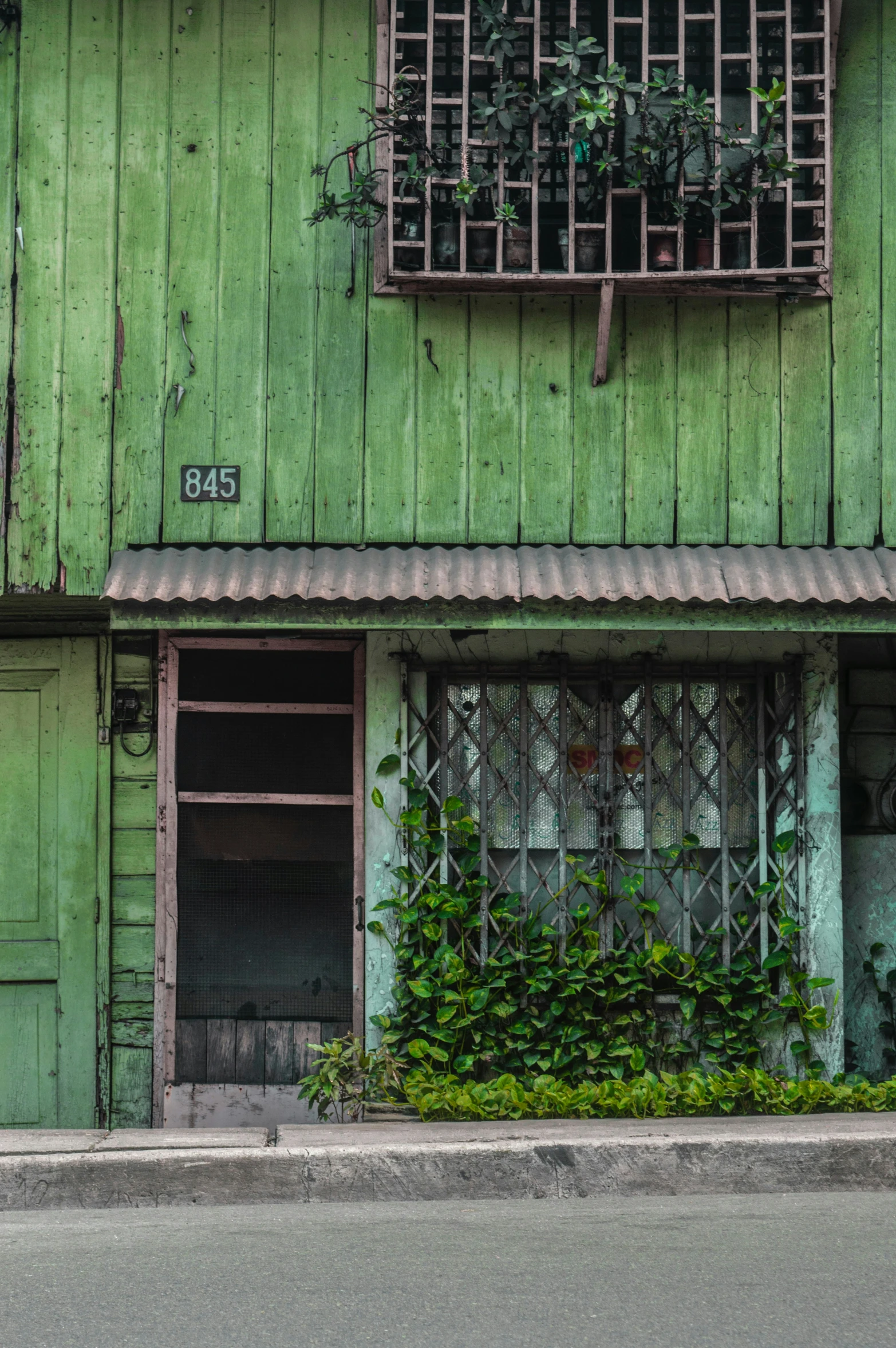 a green building with vines growing outside