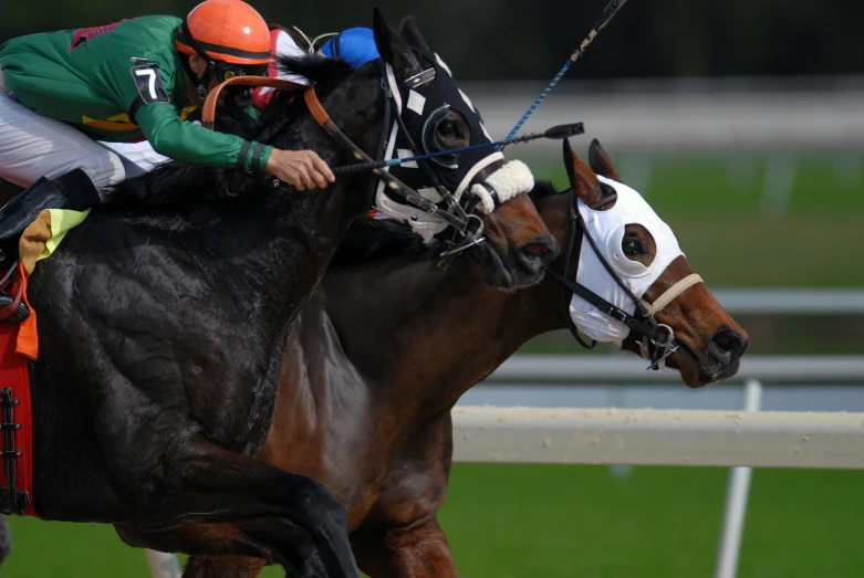 two men on a horse racing in front of other horses