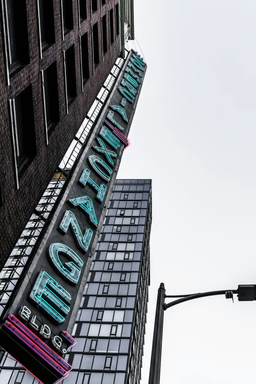 large illuminated sign on high rise building by traffic light