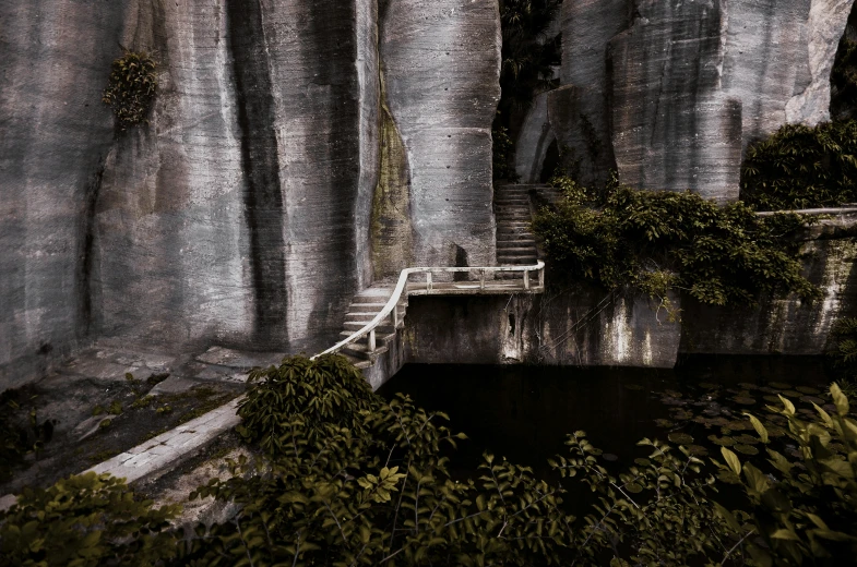 a painting of a rock cliff with a stairway leading into it