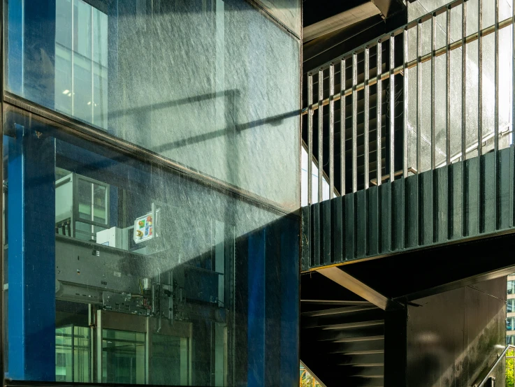 a modern glass building with stairs and a clock on top