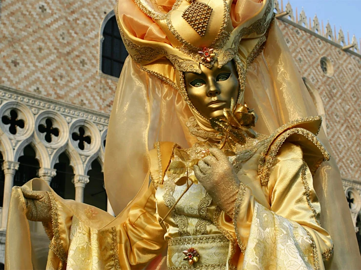 an elaborately dressed masked woman with intricate headdress