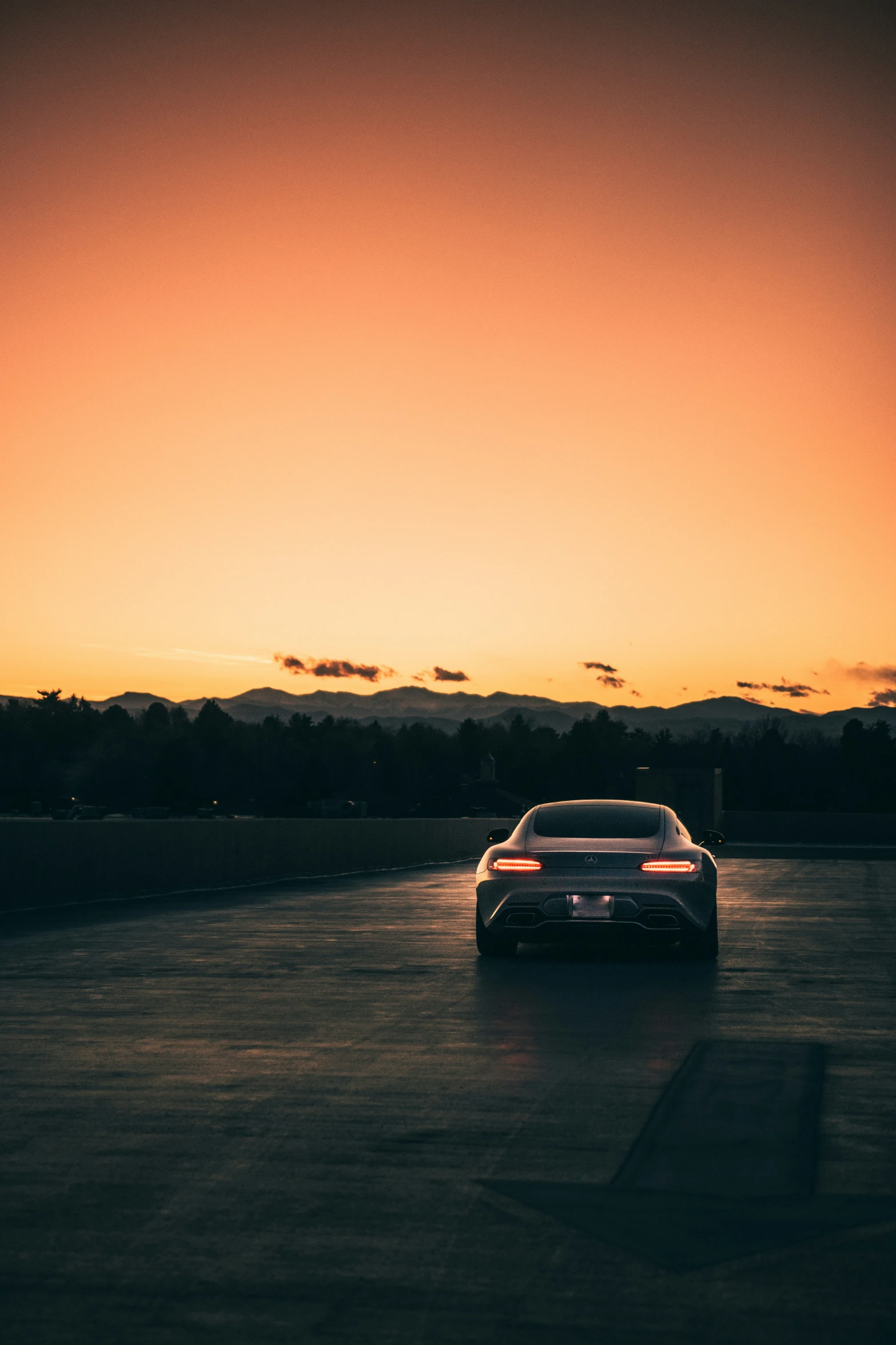 a car driving in the dark under an orange sky