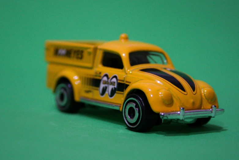 a toy car on a green surface with a sign on the top of the truck