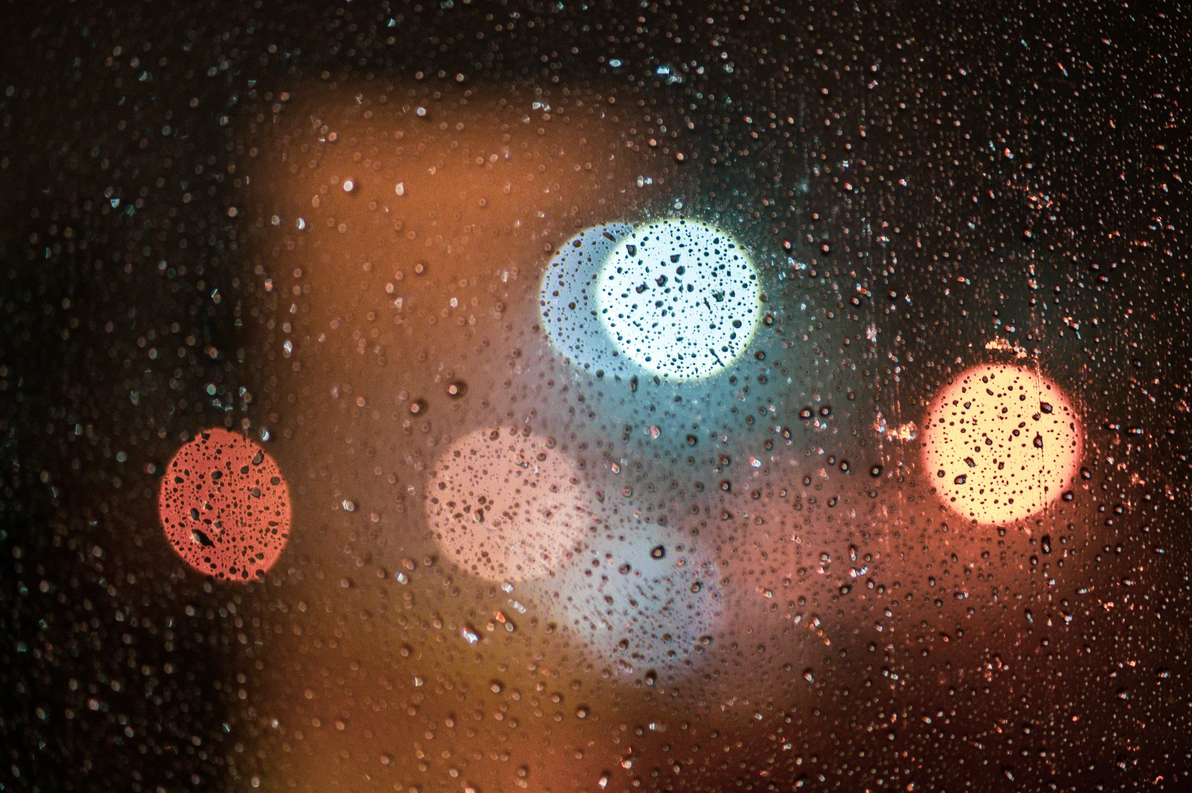 rainy window with three blurry traffic lights